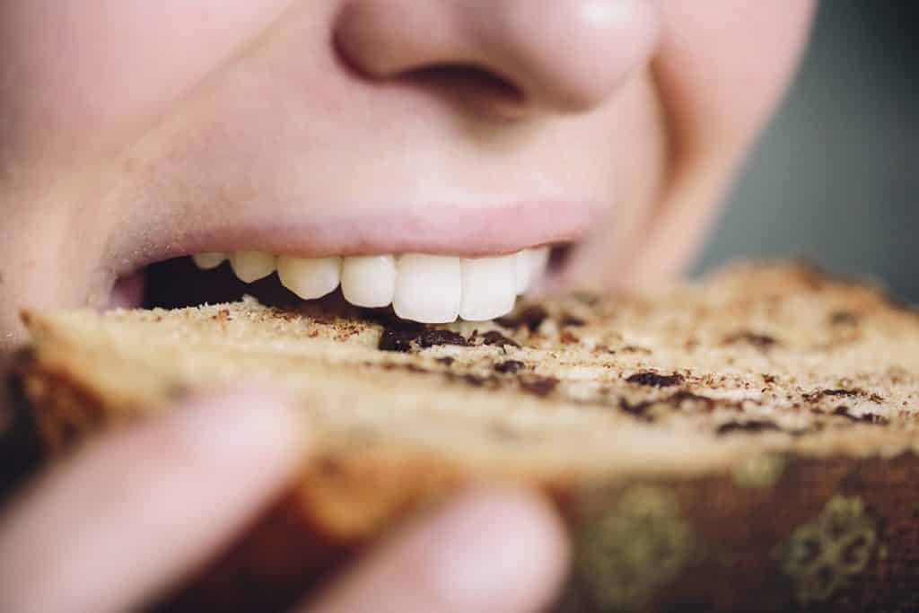 Woman Biting A Sourdough Panettone Slice